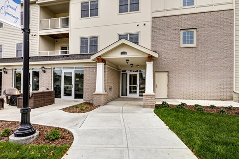 a walkway in front of a brick building with glass doors