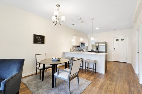 a living room with a dining room table and a kitchen