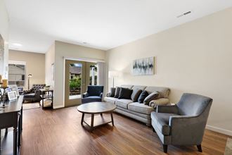 a living room with a couch and chairs and a coffee table