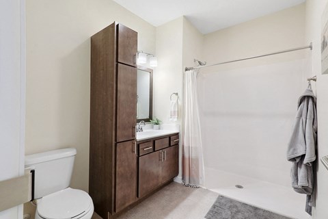 a bathroom with a shower and a toilet and a sink