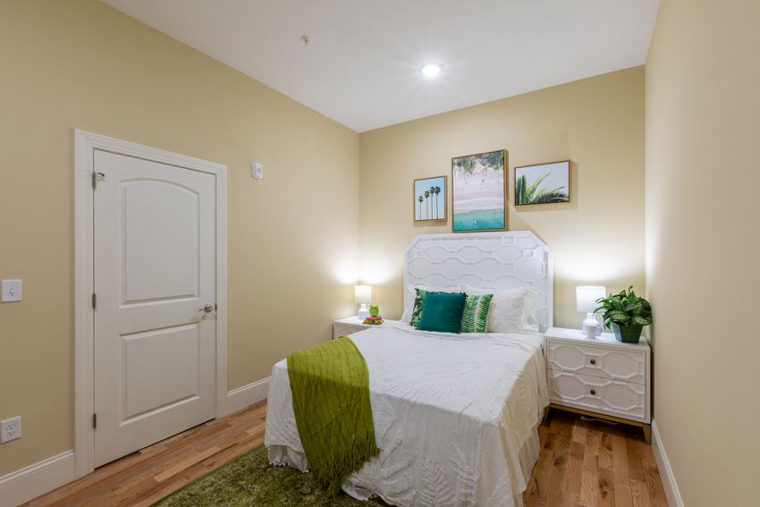 a bedroom with a white bed and a green blanket