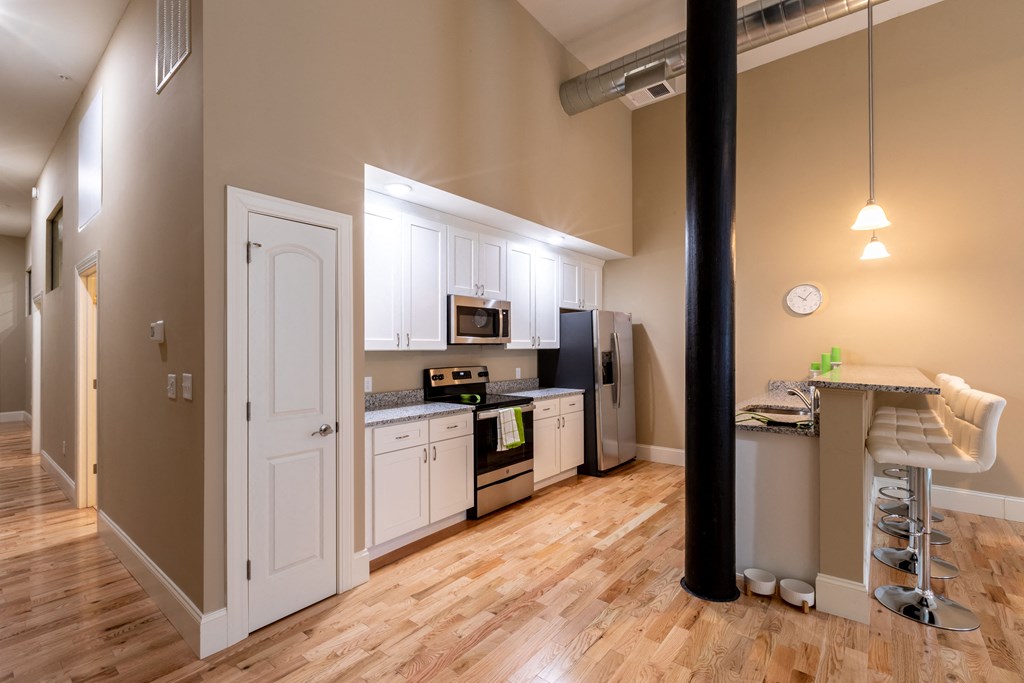 a kitchen with white cabinets and a wood floor