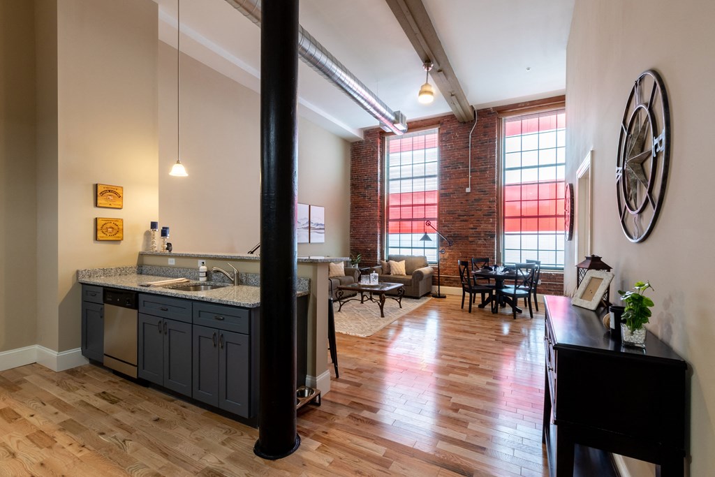 an open kitchen and living room with a large window and a table with chairs