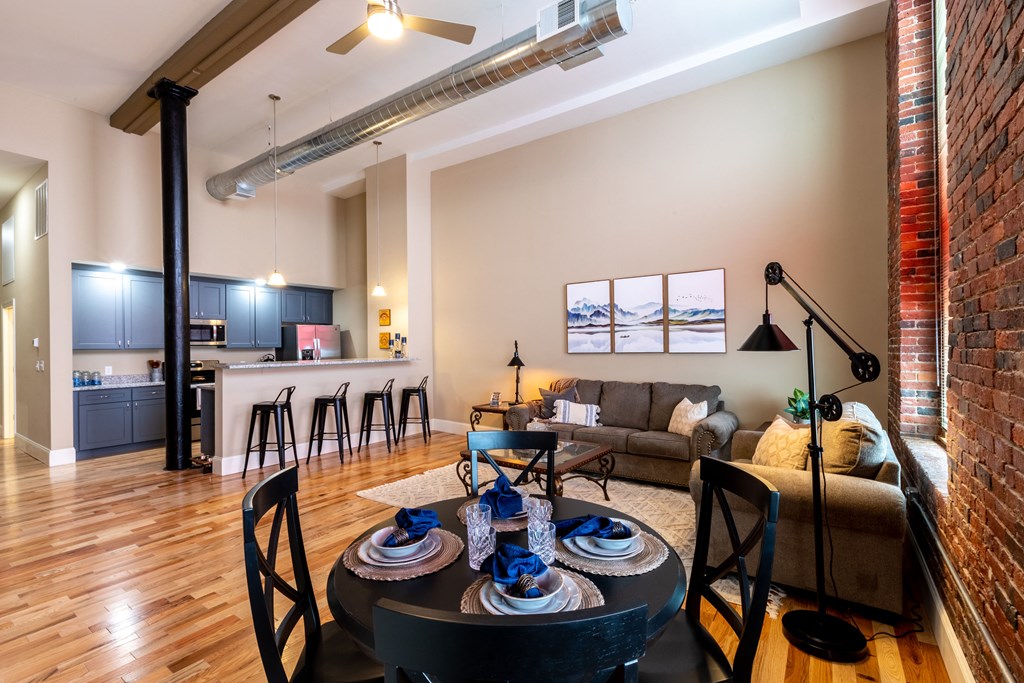 an open living room and kitchen with a table and chairs