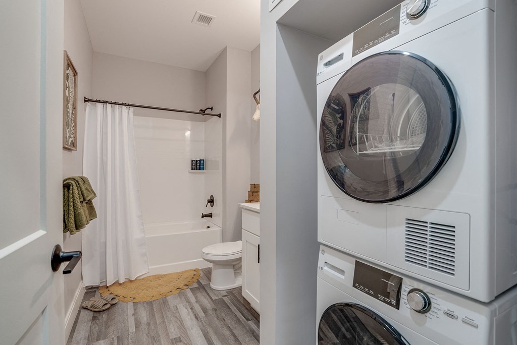 a washer and dryer in a laundry room next to a bathroom