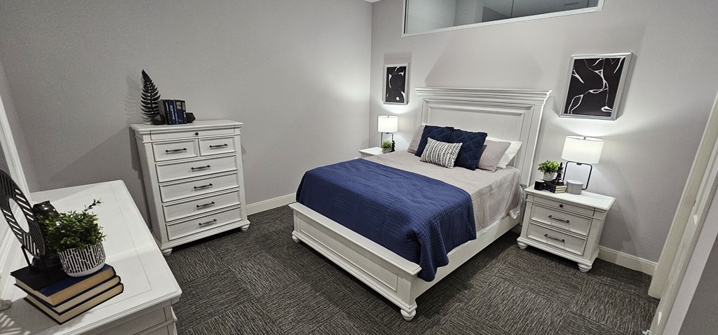 a bedroom with a white and blue bed and white furniture