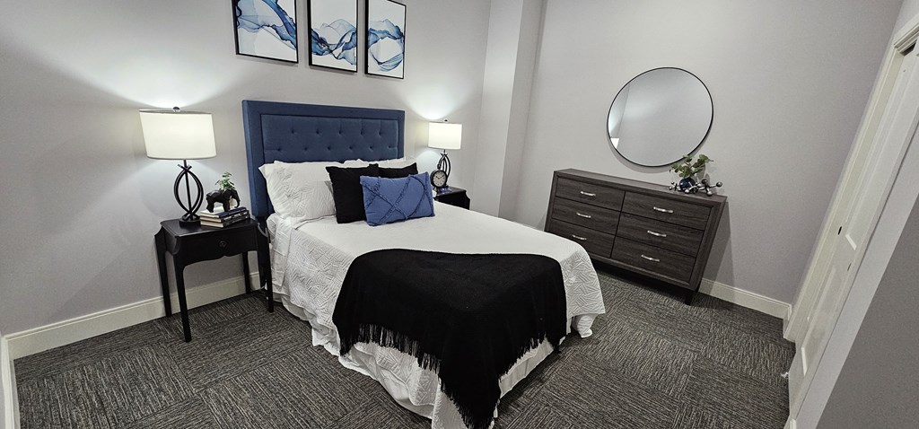 a bedroom with a bed and dresser and a mirror