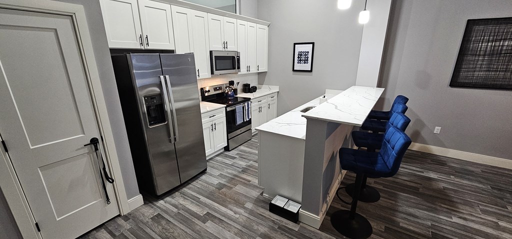 a kitchen with white cabinets and a stainless steel refrigerator