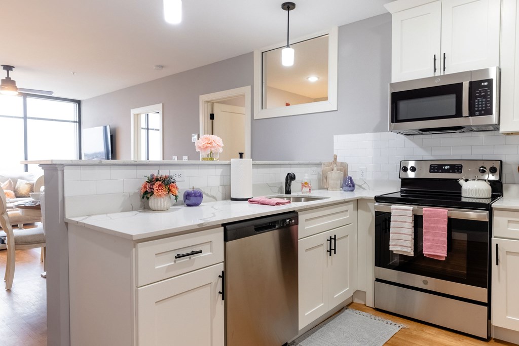 A modern kitchen with a stainless steel dishwasher and oven.
