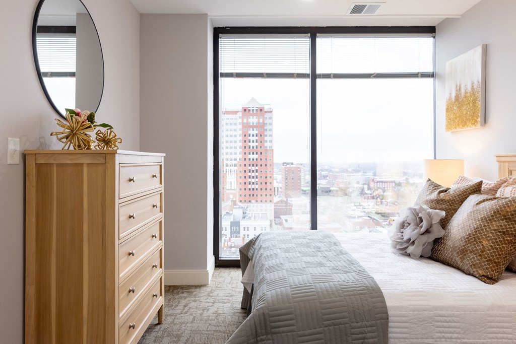 A bedroom with a large bed and a view of the city.