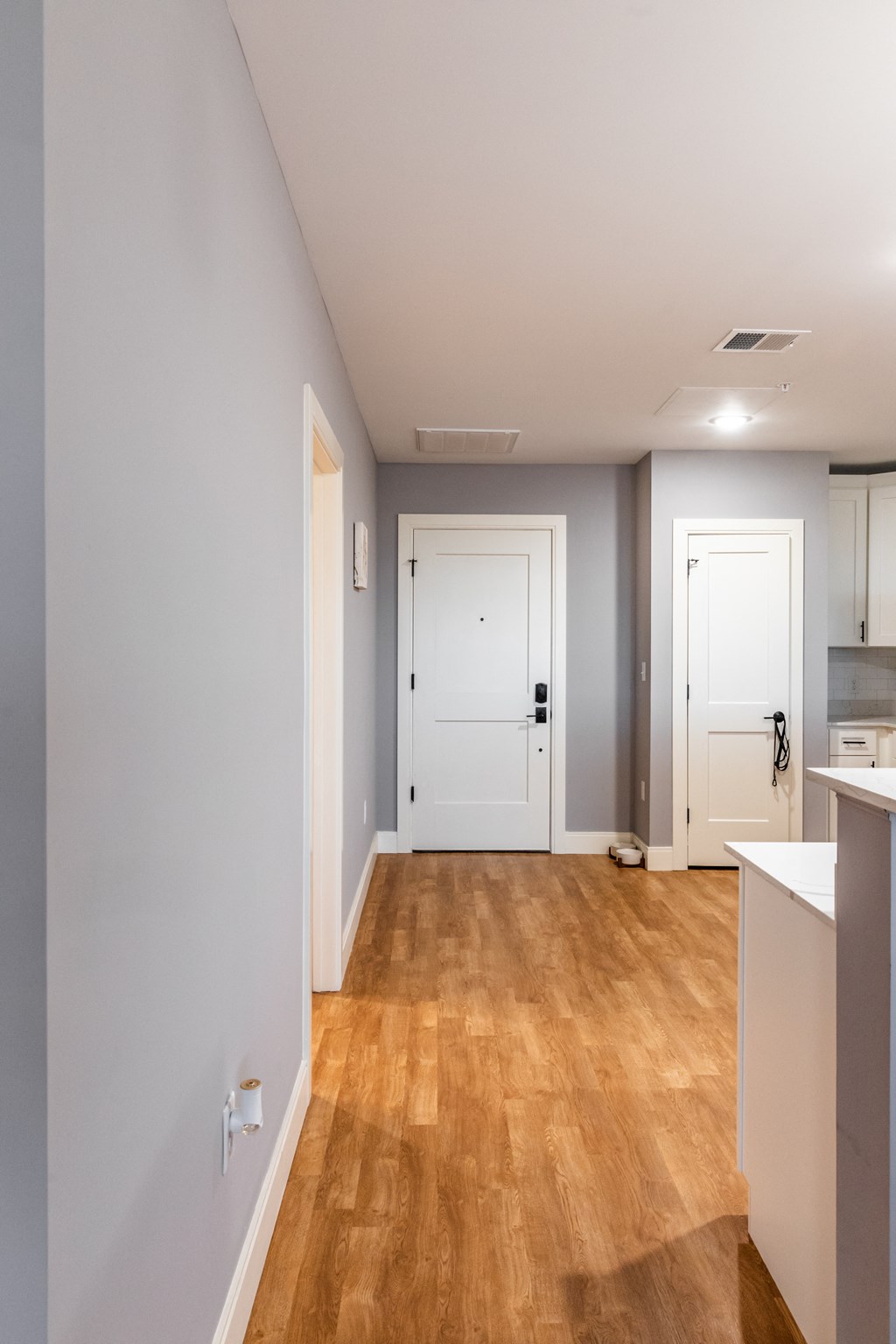 a bedroom with a medium sized bed and a kitchen with white cabinets