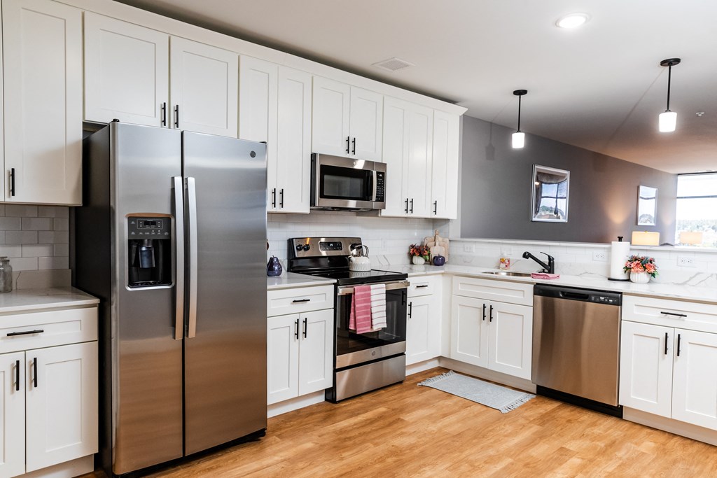 a kitchen with white cabinets and stainless steel appliances
