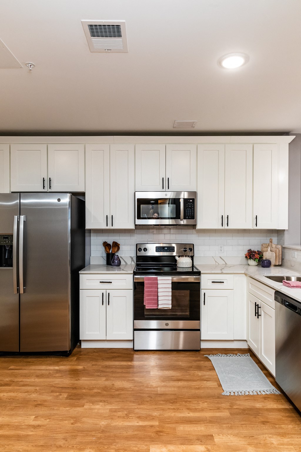 a kitchen with white cabinets and stainless steel appliances