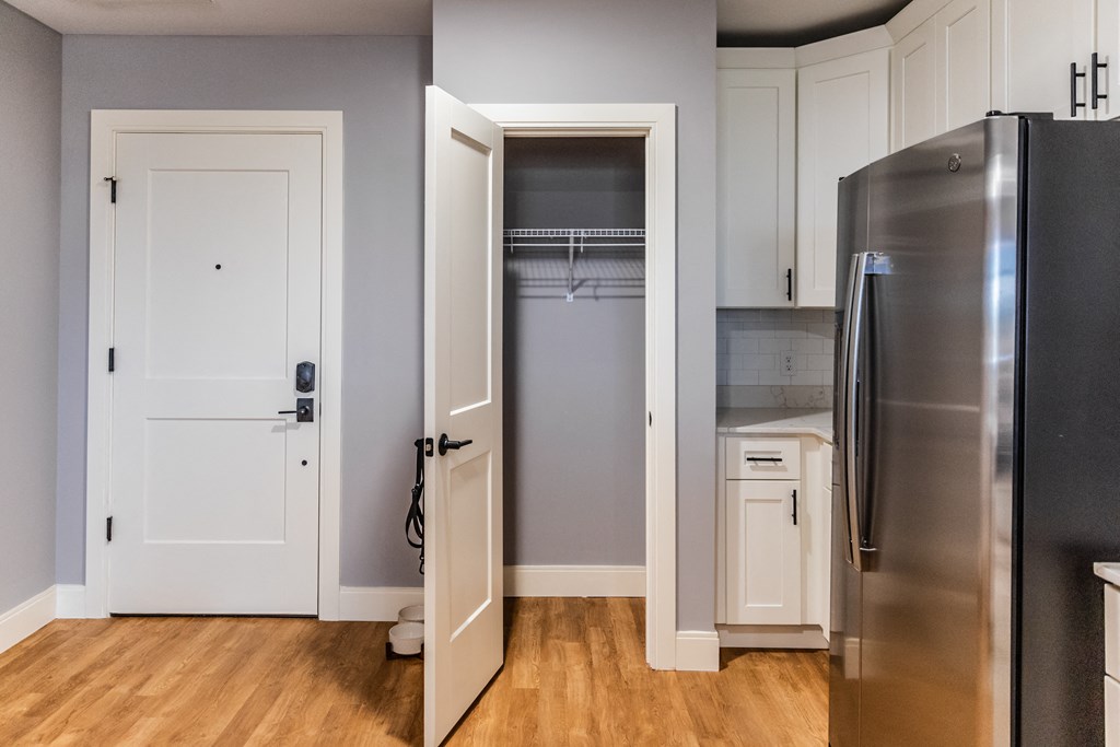 a kitchen with white cabinets and a stainless steel refrigerator