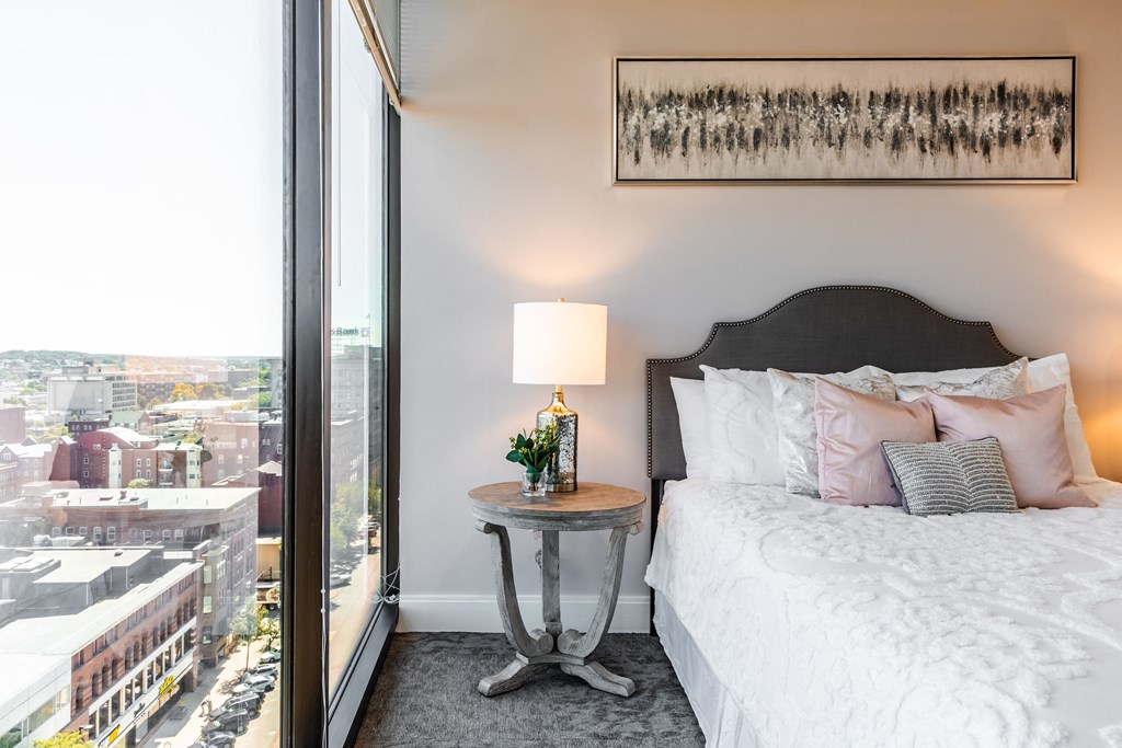 a bedroom with a bed and a large window