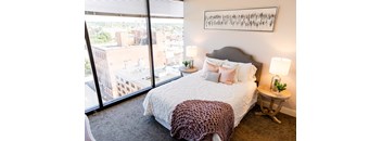 a bedroom with a large window and a leopard print bedspread