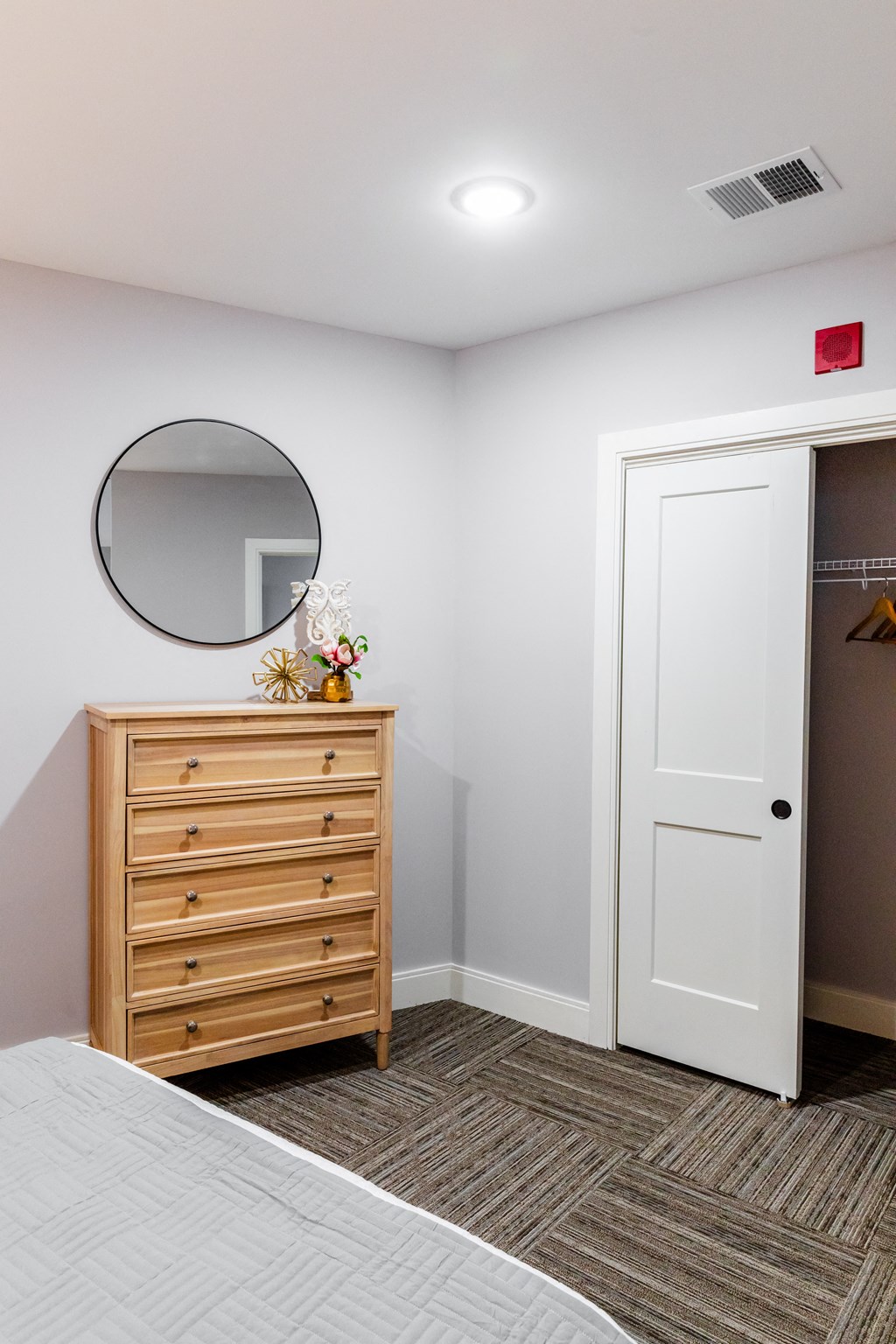 a bedroom with a dresser and mirror
