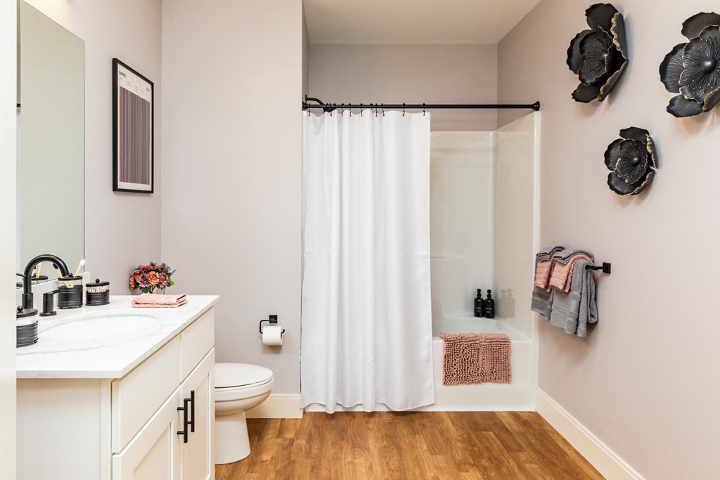 a bathroom with a white sink and toilet and a white shower curtain