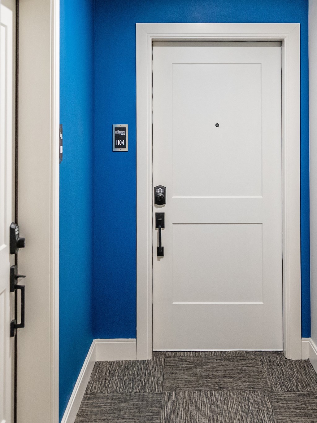 a white door with a black handle in a blue room