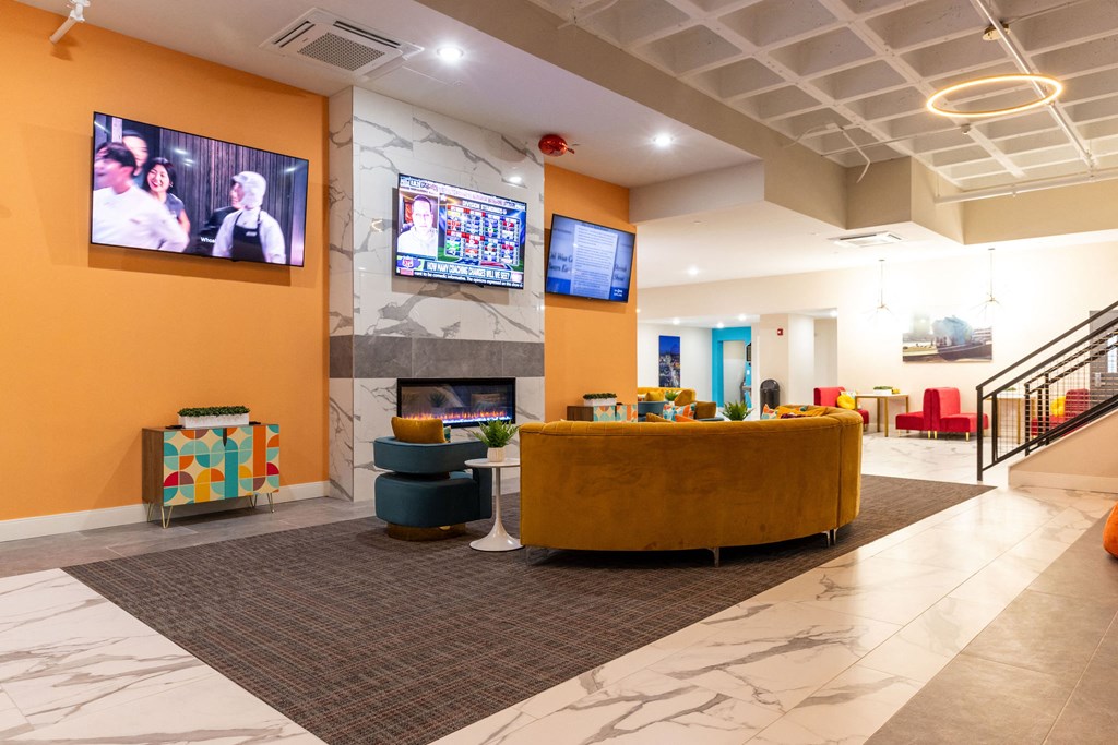 a lobby with a couch and a fireplace and a tv