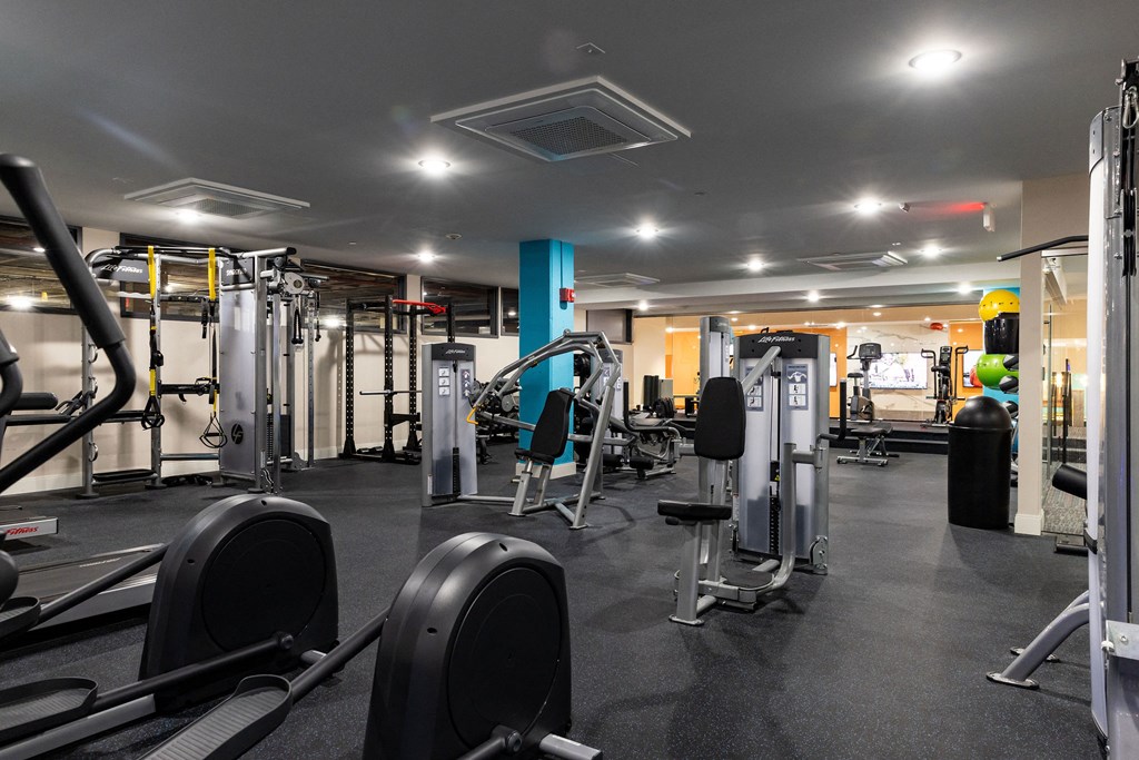 a gym with weights and cardio equipment in a building
