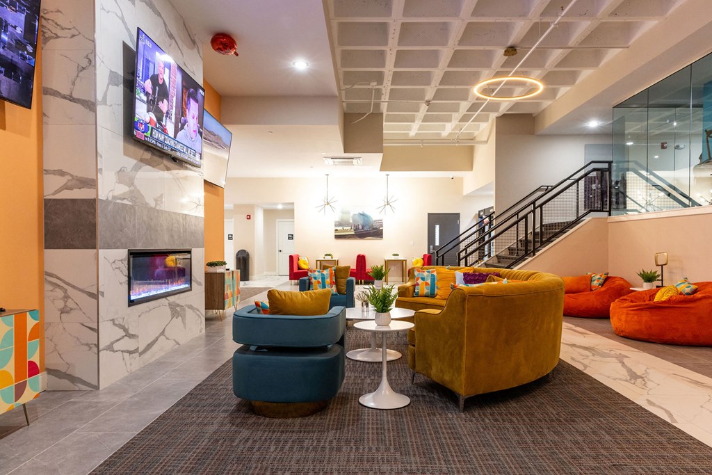 a lobby with couches and chairs and a television