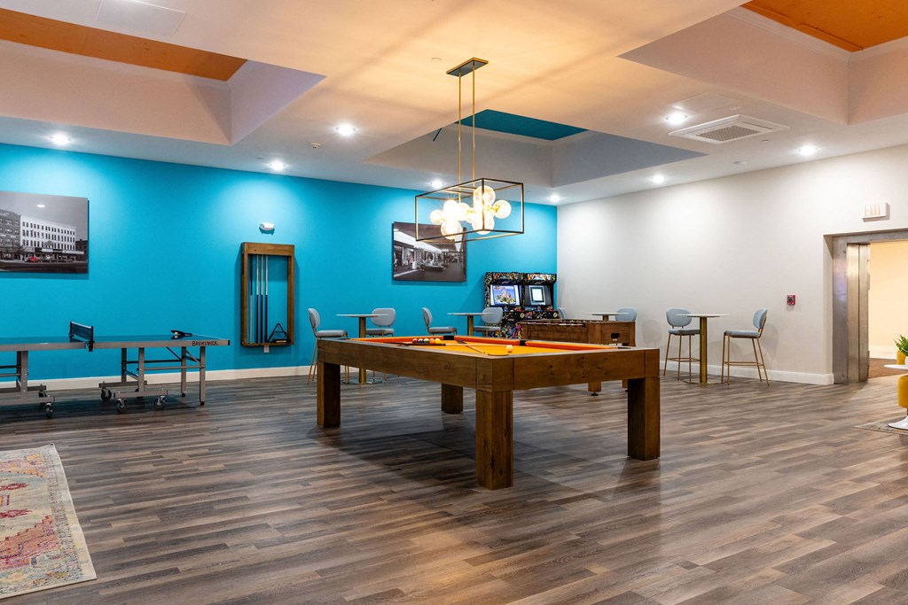a large pool table in a room with a blue accent wall and a game room