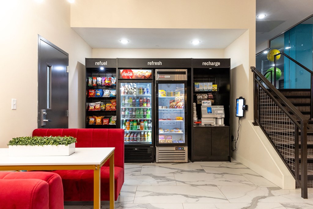 a lobby area with red couches and refrigerators    and a staircase