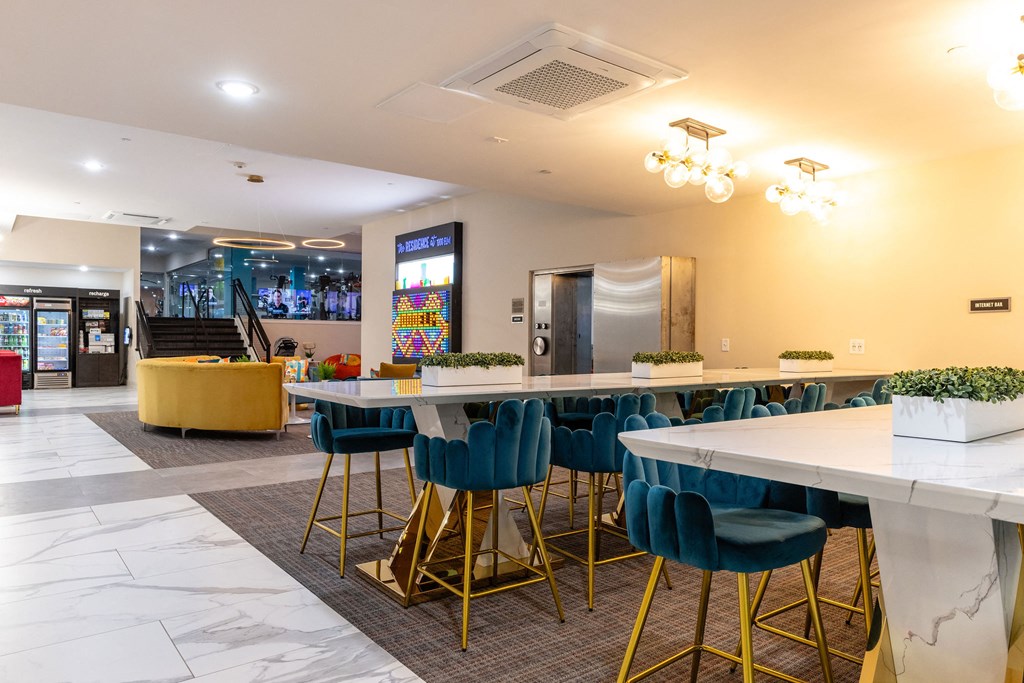 a long communal table with blue chairs in a lobby