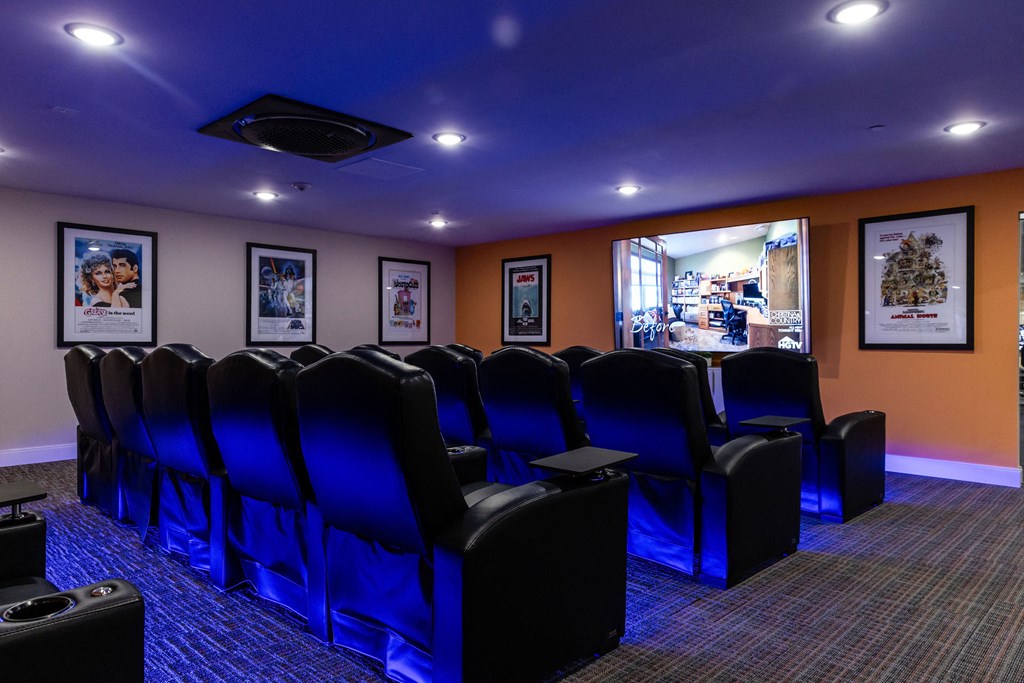 a theater room with blue chairs and a projector screen