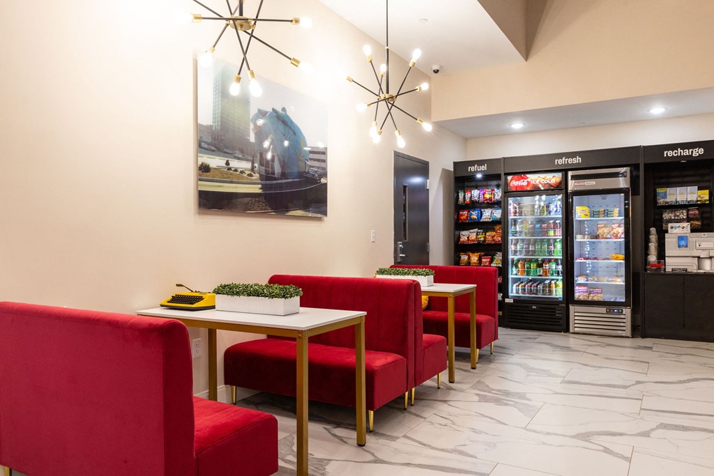 a dining room with red chairs and tables in front of refrigerators