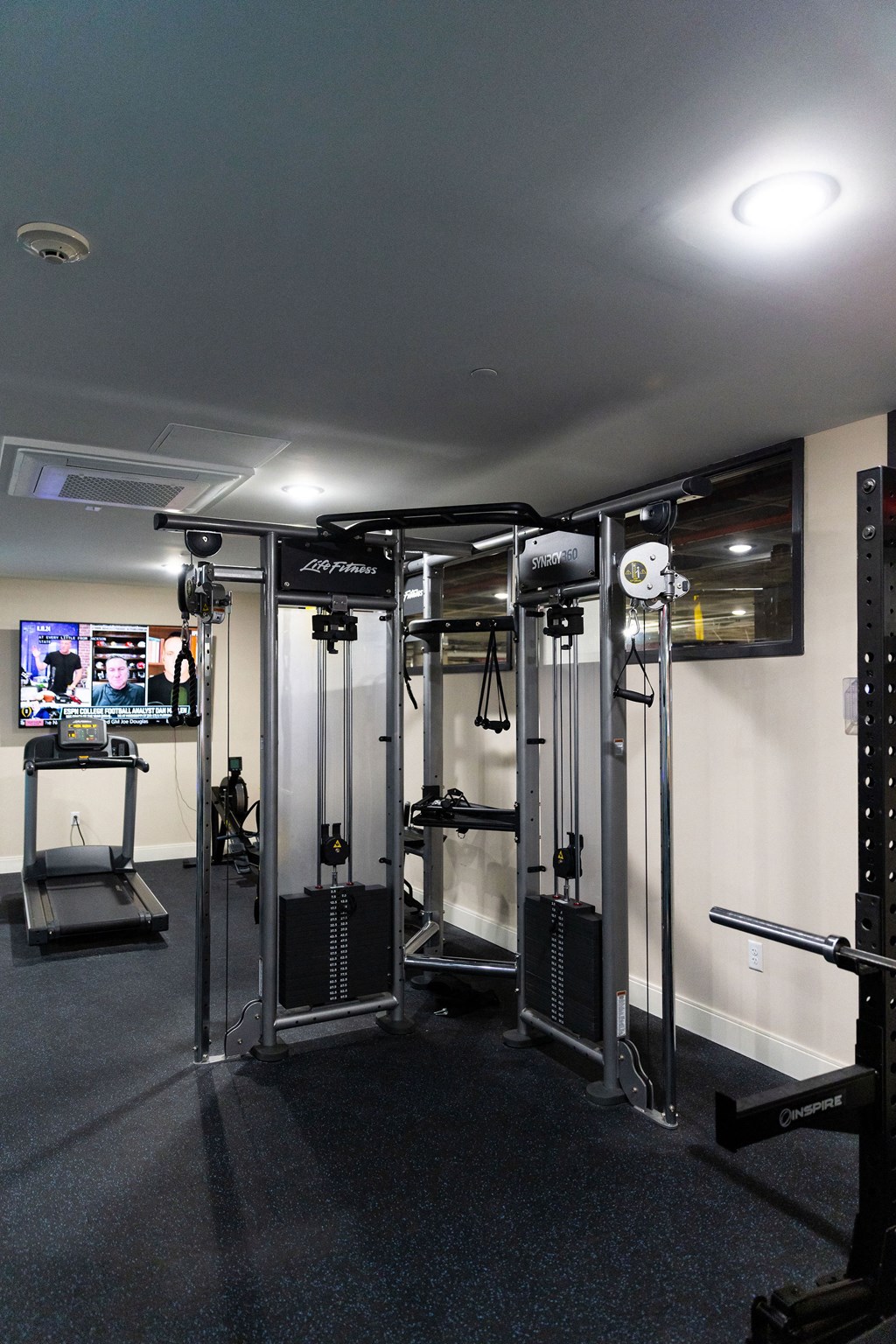 a fitness room with exercise equipment in a home gym