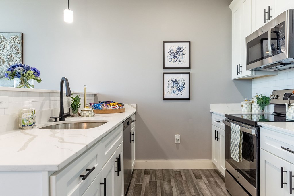 A kitchen with a white counter top and a sink.