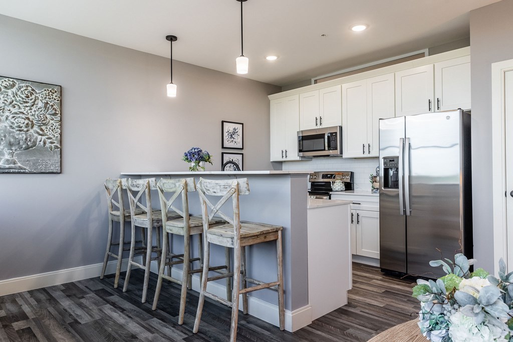 A kitchen with a bar area and a refrigerator.