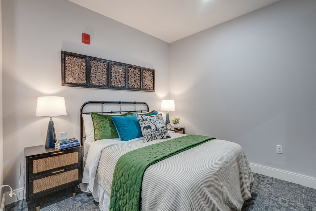 a bedroom with a bed and two lamps