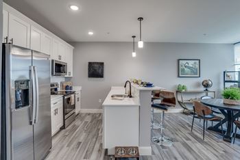 A modern kitchen with a refrigerator, stove, and sink.