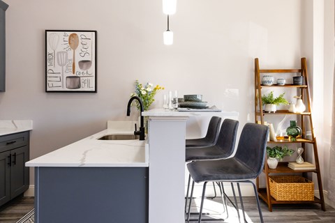 A kitchen with a white counter and a sink.