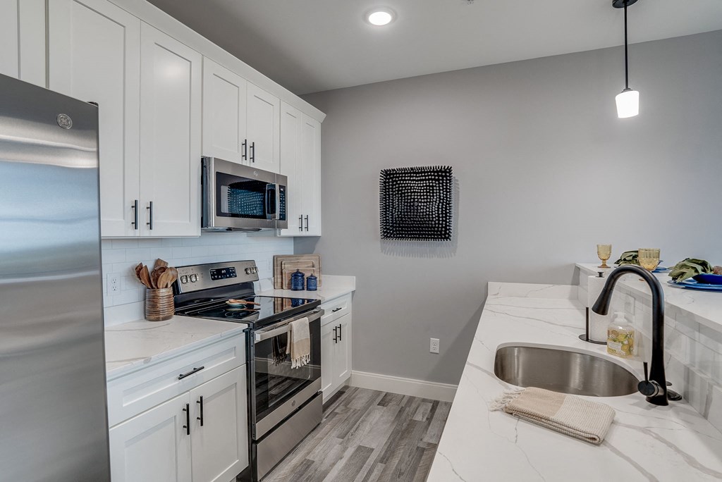 a kitchen with white cabinets and stainless steel appliances