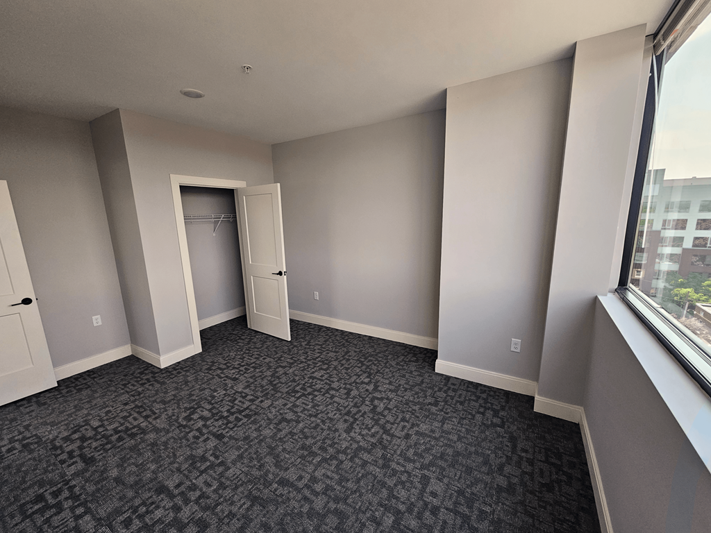 an empty living room with a large window and a door