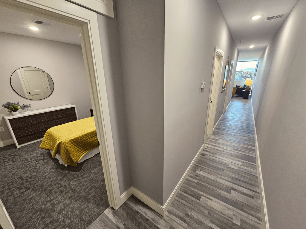 a corridor with a bed and a mirror in a house