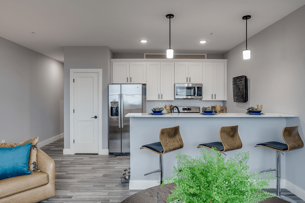 a kitchen and living room with white cabinets and a counter