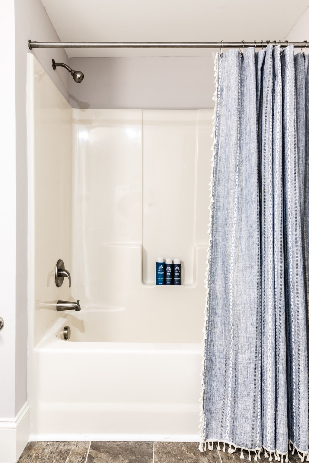 a bathroom with a white bathtub and a blue shower curtain