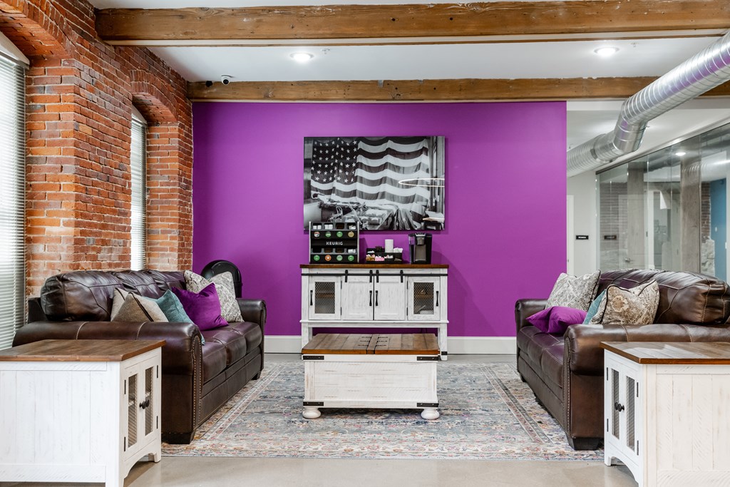 a living room with a purple wall and leather furniture