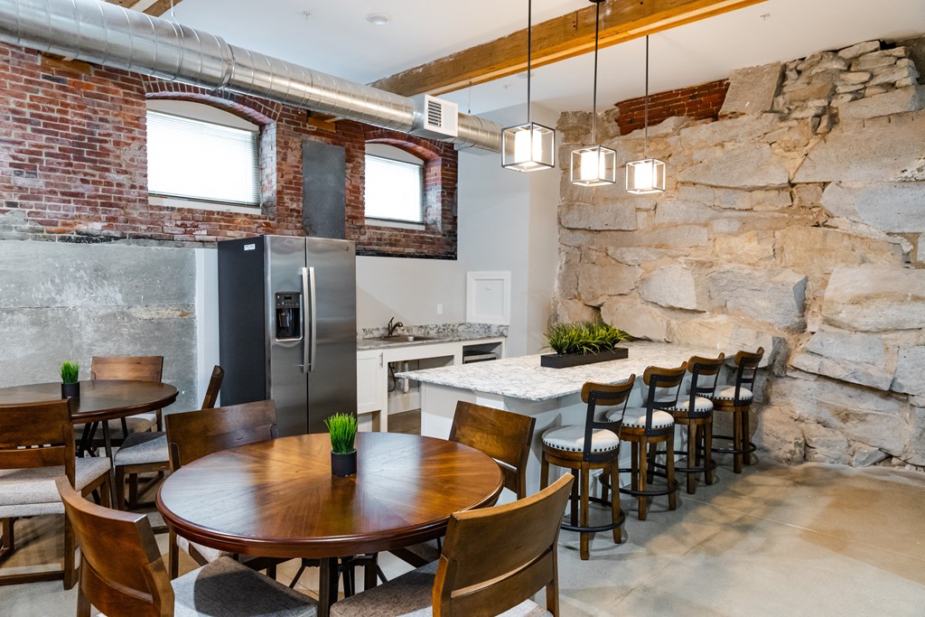 a kitchen with a stone wall and a table and chairs