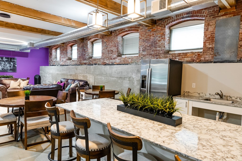 the kitchen and living room of a loft with a kitchen island and bar stools