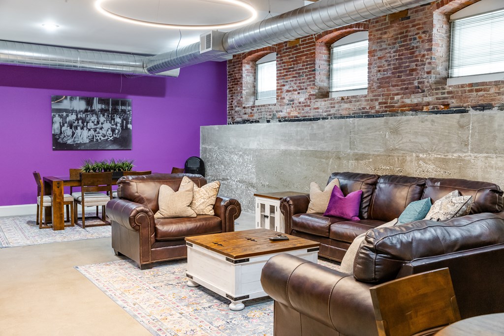 a living room with purple walls and leather furniture