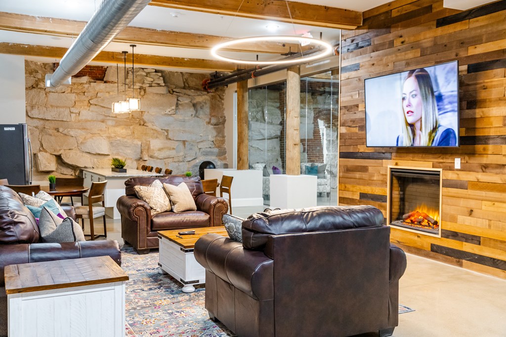 a living room with couches and a fireplace and a tv
