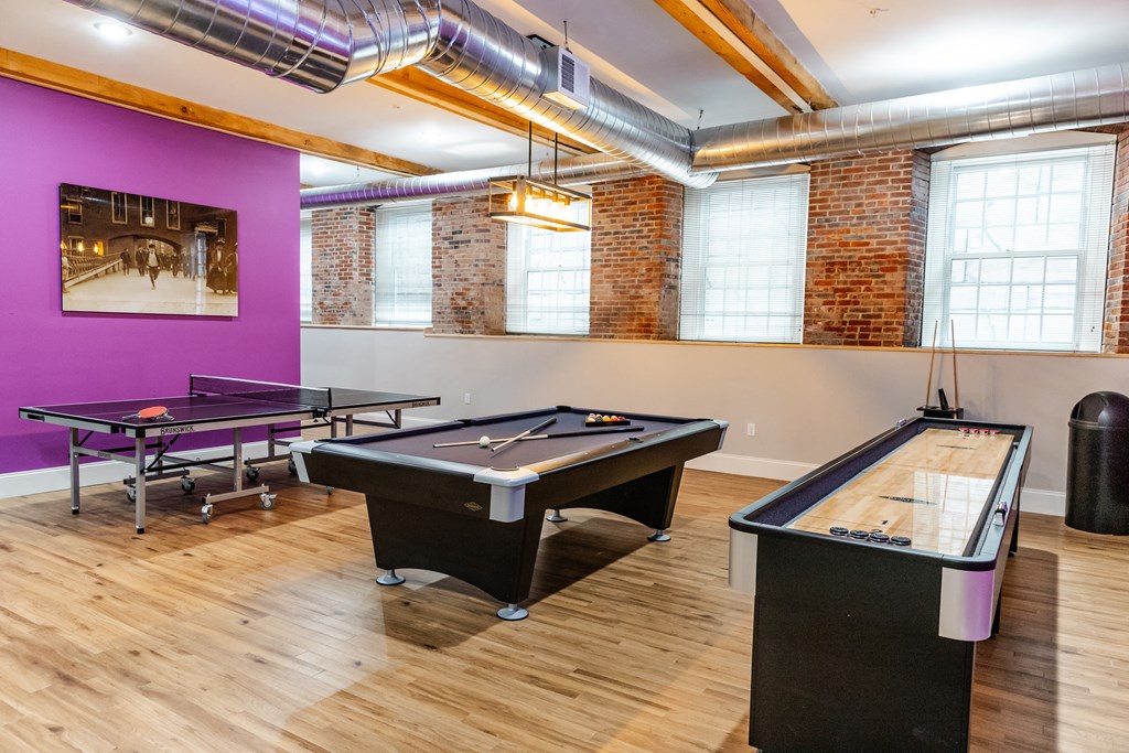 a game room with two pool tables and a ping pong table