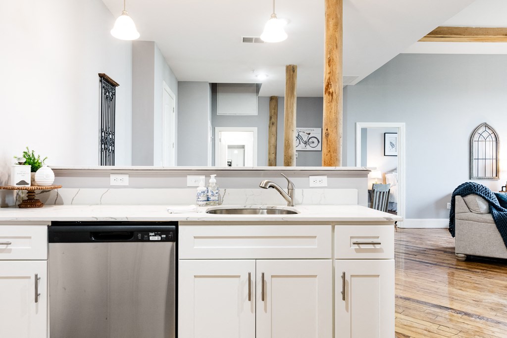 a kitchen with white cabinets and a stainless steel dishwasher