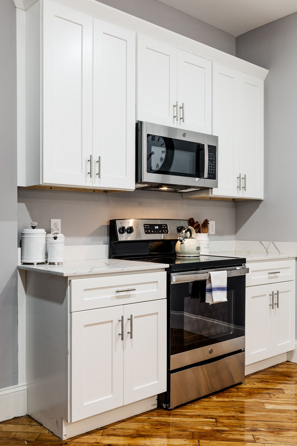 a kitchen with white cabinets and stainless steel appliances